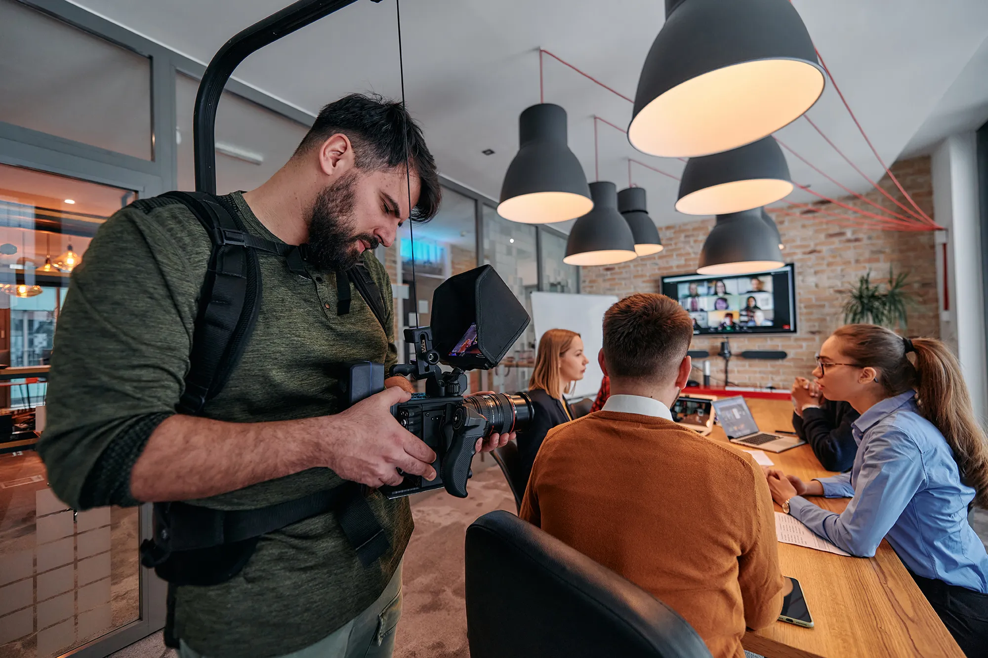 Operator z kamerą filmuje spotkanie zespołu w biurze